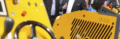 Zwei Männer inspizieren eine große gelbe Industriemaschine auf der bauma.