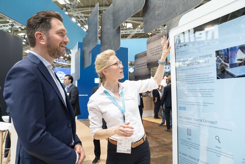 Messebesucher interagieren mit Touchscreen auf der transport logistic