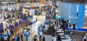 Bird's eye view of Hall A1 at the World of Quantum, with many modern exhibition stands and visitors.
