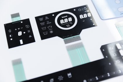 Nahaufnahme eines schwarz-weißen elektronischen Bedienfelds mit verschiedenen Tasten und Digitalanzeigen.
