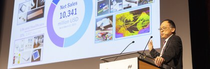 Podium auf der LOPEC mit einer Präsentationsfolie zum Thema intelligente Kommunikation, inklusive Bildmaterial und Marktstatistiken.