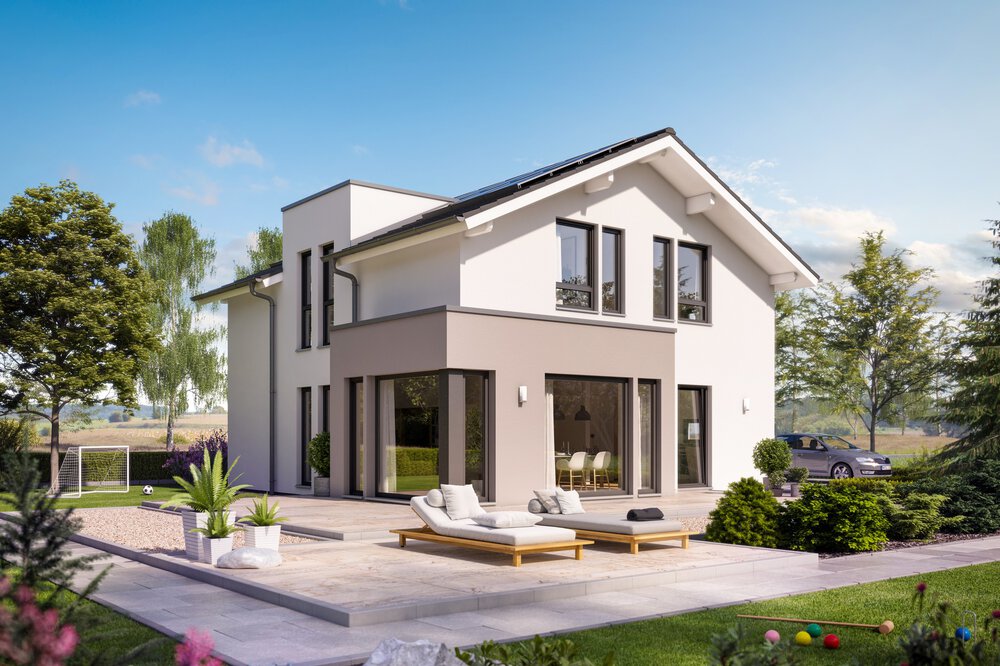 Modernes zweistöckiges Haus mit Terrasse, umgeben von grünem Rasen, bunten Pflanzen und Bäumen unter einem klaren blauen Himmel.
