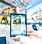 Person holding up a tablet for digital representations of a construction site at Hexagon's stand at bauma 2022