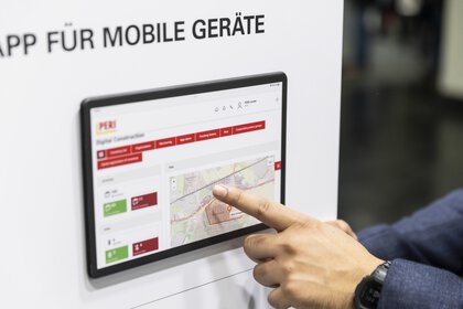 A finger points to a wall-mounted control display.