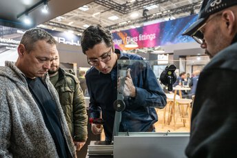 Mehrere Personen stehen um ein Messe-Exponat herum und tauschen sich dazu aus.