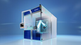 A large rectangular semi-transparent machine with partially blue panes, containing a monitor and a robotic arm inside.