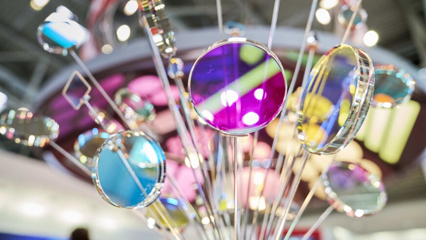 A bouquet of glass rods with colorful shimmering glass panes or lenses mounted at the end.