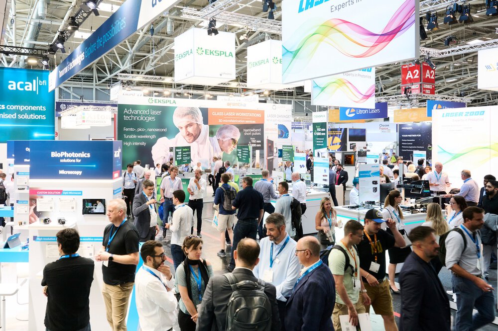 A crowd of people mingling at a busy technology trade fair with stands and banners from various companies.
Consistently digitalising