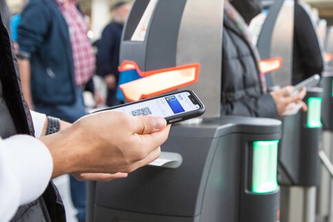 Person scans QR code with smartphone at the entrance to the bauma exhibition area.
