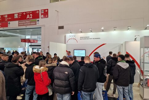 Eine große Ansammlung von Messebesuchern steht vor dem Stand des 
