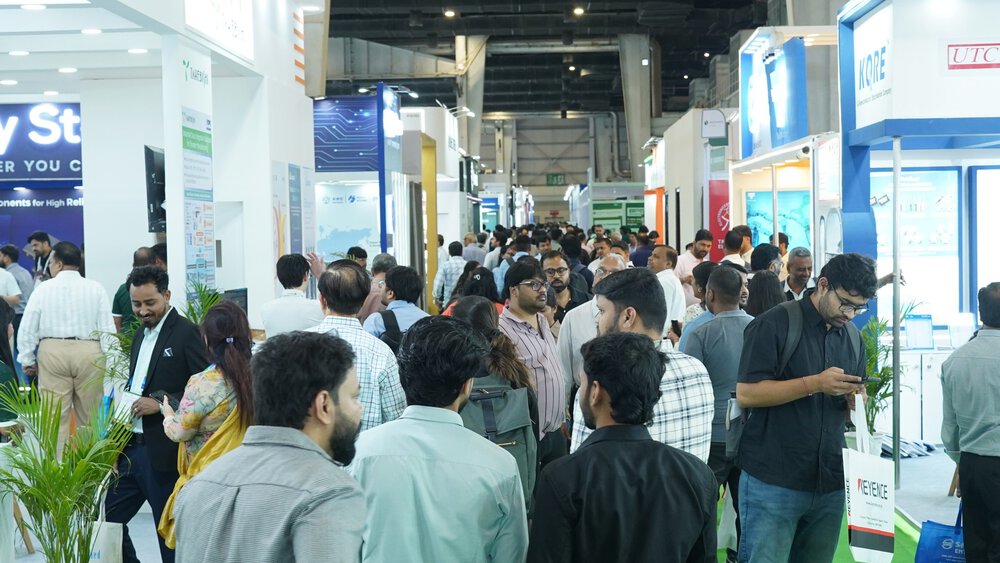 A crowd moving through a bustling trade show or exhibition with booths and displays, making connections.