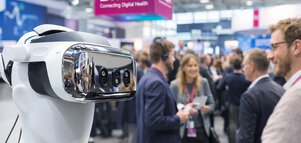 VR headset in focus at DMEA with professionals networking about digital health in the background