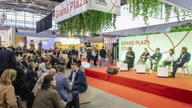 The Grand Plaza at EXPO REAL serves as a central hub for networking, conversations, and presentations in a vibrant trade fair atmosphere.