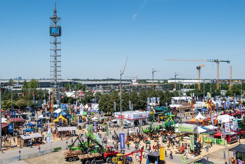 Luftaufnahme des Freigeländes der Messe München während der INTERFORS, Blick auf den Messeturm, Stände, Pavillions, Forstmaschinen und Baukräne.