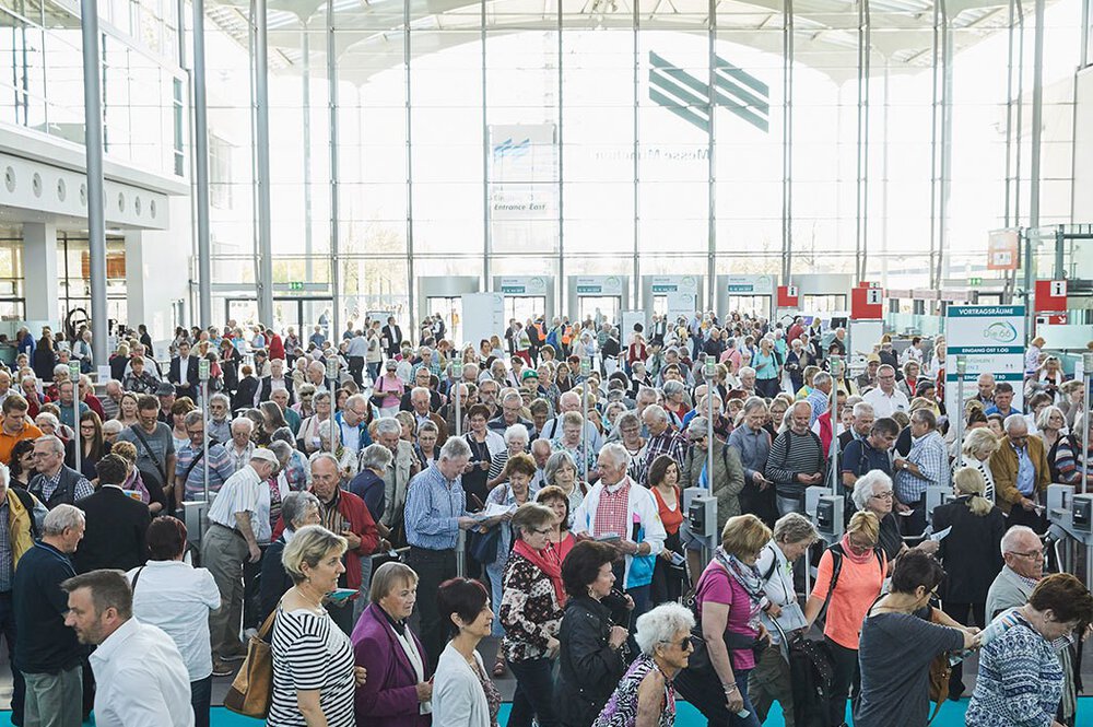Besucher der Die 66 am Eingang Ost der Messe München