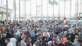 Besucher der Die 66 am Eingang Ost der Messe München