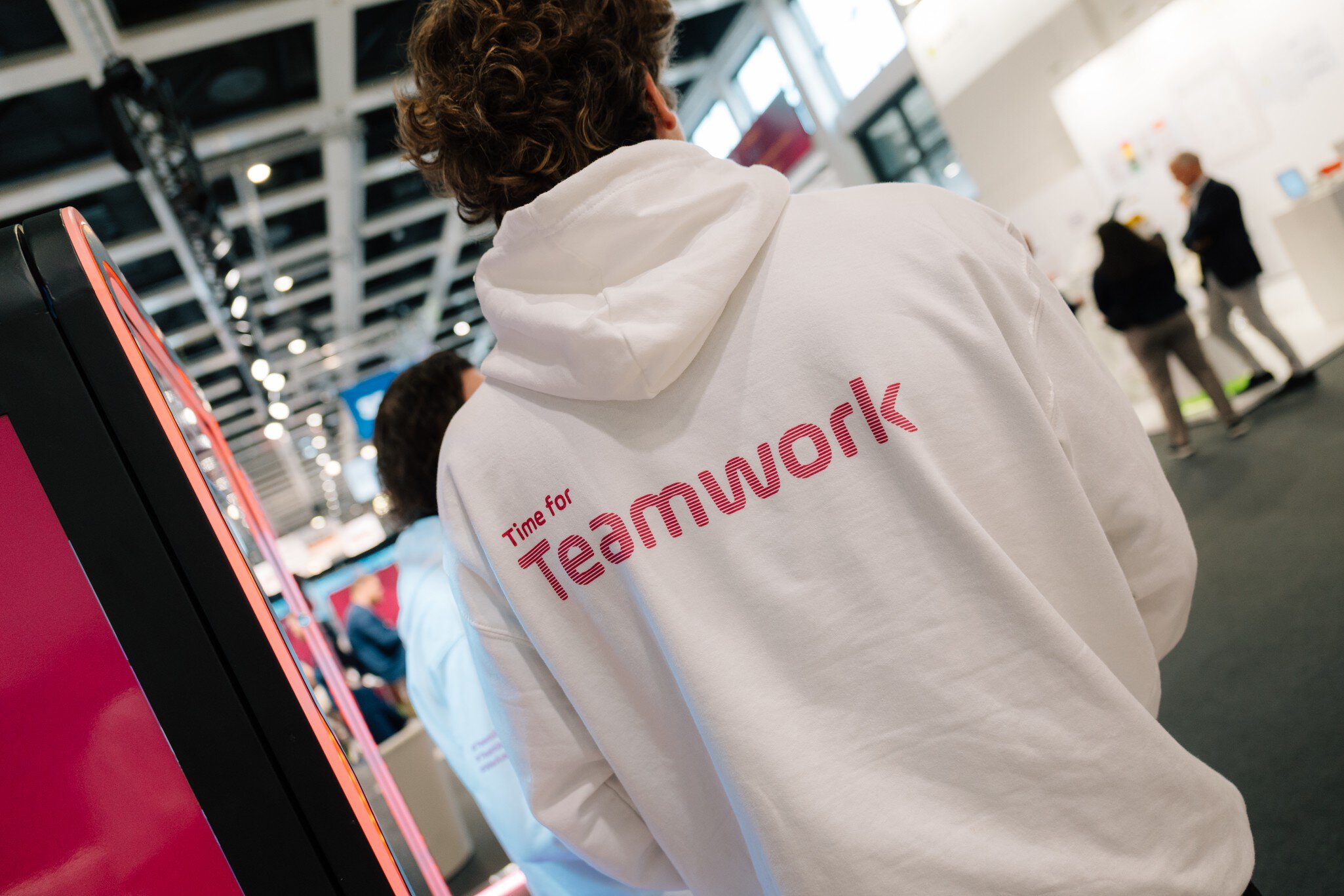 Person im weißen Hoodie mit Schriftzug „Time for Teamwork“ auf der DMEA