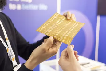 Two people holding a flexible electronic circuit board with a blurred background.