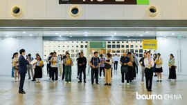 A group of people are standing in front of entrance H3-2 at an indoor event, where signage for bauma CHINA can be seen.