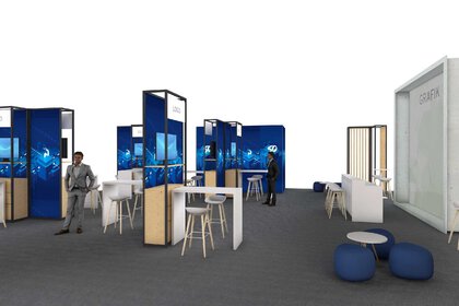 Die Visualisierung zeigt ein modernes Messekonzept mit klar strukturierten Informationsständen, ausgestattet mit digitalen Bildschirmen und Logos. Die Gestaltung dominiert in Blau- und Holztönen, ergänzt durch weiße Stehtische und Barhocker für Gespräche auf Augenhöhe. Eine Lounge-Zone mit runden Hockern und niedrigen Tischen bietet Platz für informelle Meetings. Im rechten Bereich ist eine große Fläche für Grafik- und Markenpräsentationen vorgesehen. Die Szene vermittelt einen offenen, einladenden und professionellen Messeauftritt, ideal für Networking und Produktpräsentationen.
