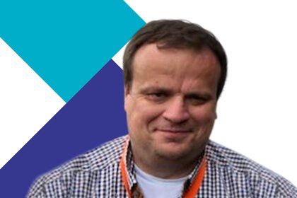 Man in a checked shirt with a blue and purple geometric background.