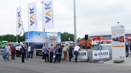 Besucher bei der Live-Demonstration ‚Truck in Action‘ von VAK auf der IFAT Munich, mit großen VAK-Bannern, Nutzfahrzeugen und Partner-Branding im Outdoor-Bereich.