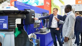 A consultant at the Klaro stand explains the digital control system of a wastewater treatment plant to a visitor.