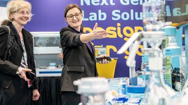 Zwei Frauen bei einem Gespräch über ein Laborgerät