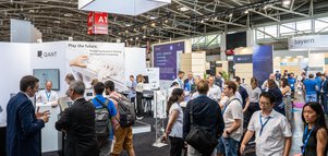 Zahlreiche Menschen in der Halle A1, vor einem Messestand der Firma 