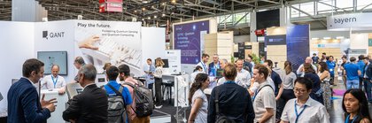 Zahlreiche Menschen in der Halle A1, vor einem Messestand der Firma 