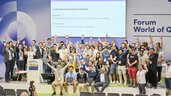 Gruppenfoto bei der Award Ceremony des Qiskit Hackathons auf der World of Quantum 2025 in München, alle jubeln auf der Bühne.