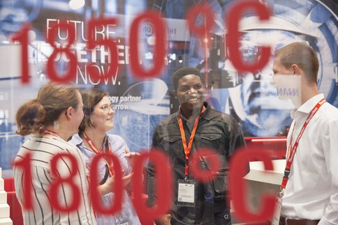 People discussing behind glass with red numbers, text reads 