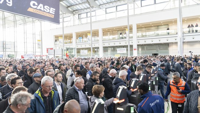 Menschenmenge wartet im Eingangsbereich der Messe.