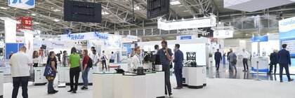 ein telefonierender Mann sieht sich einen Messestand an