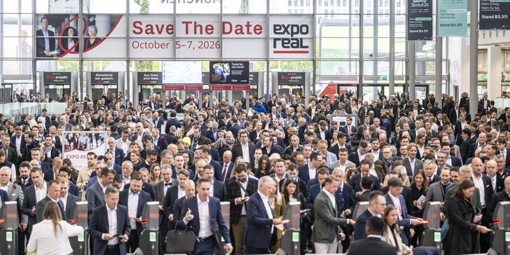 A large crowd enters a convention center for Expo Real, with a banner displaying the event dates in October 2026.