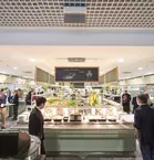 Symmetrical view of a busy cafeteria with drinks and food of all kinds.