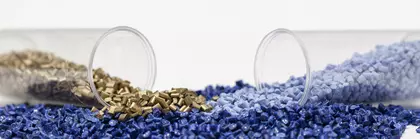 Two horizontal, open test tubes with blue and gold grains against a white background.