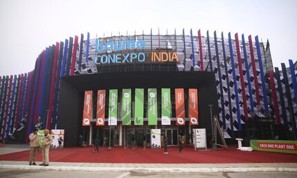 Colourful facade of the Bauma CONEXPO India entrance area with banners and red carpet.