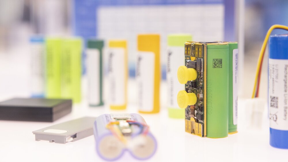 Several capacitors and capacitor modules are displayed on a bright white pedestal.