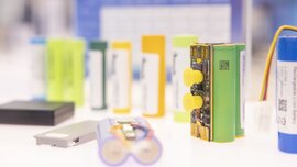 Several capacitors and capacitor modules are displayed on a bright white pedestal.