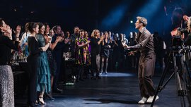 Singer in a brown outfit captivates the clapping audience at the foot of the stage at the INHORGENTA AWARD Gala.