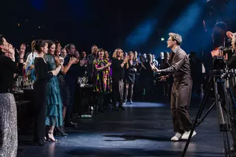 Singer in a brown outfit captivates the clapping audience at the foot of the stage at the INHORGENTA AWARD Gala.