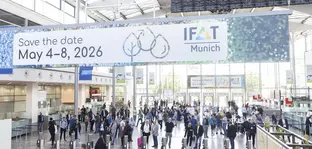 Crowd in the entrance hall of the trade fair. In focus is a sign hanging from the ceiling with the inscription “IFAT Munich: Save the date May 4-8, 2026”