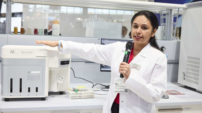 a woman in a lab coat gives a lecture