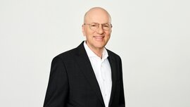 In the photo, you can see Dr. Pfeiffer, CEO of Messe München Group, wearing a suit and smiling.