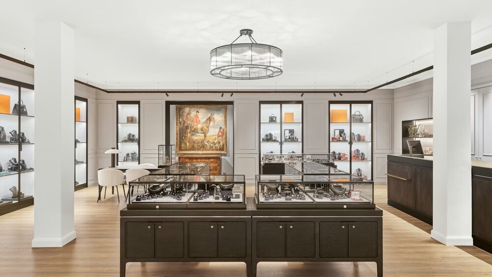 A large salesroom with two columns, a round chandelier, and numerous square display cases in which jewelry is presented.