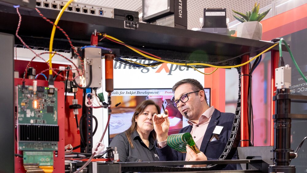 Exhibitor explaining printed electronics within a large inkjet process demonstration setup