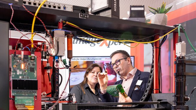 Aussteller erläutert gedruckte Elektronik in einer großen Demonstrationsanlage für Inkjet-Prozesse