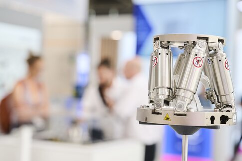 Laser Medizintechnik: Nahaufnahme eines präzisen, metallischen Hexapod-Positioniersystems mit mehreren Hydraulik- bzw. Pneumatikzylindern