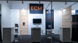 Messestand mit ECM-Logo, zentralem Monitor, Regalen und minimalistischem Design.
